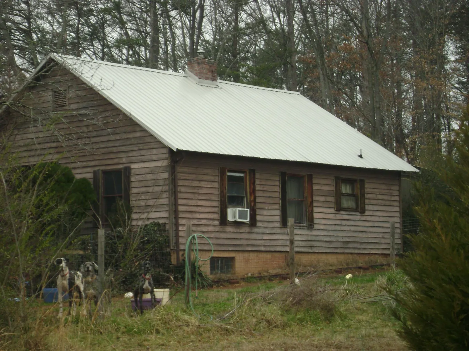 White metal roof on an old wood sided farmhouse, from a Metal Roof Installation job in Ashville